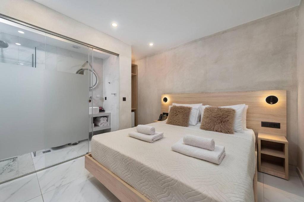 a bedroom with a large bed with a glass wall at Evdokia Artheon in Rhodes Town