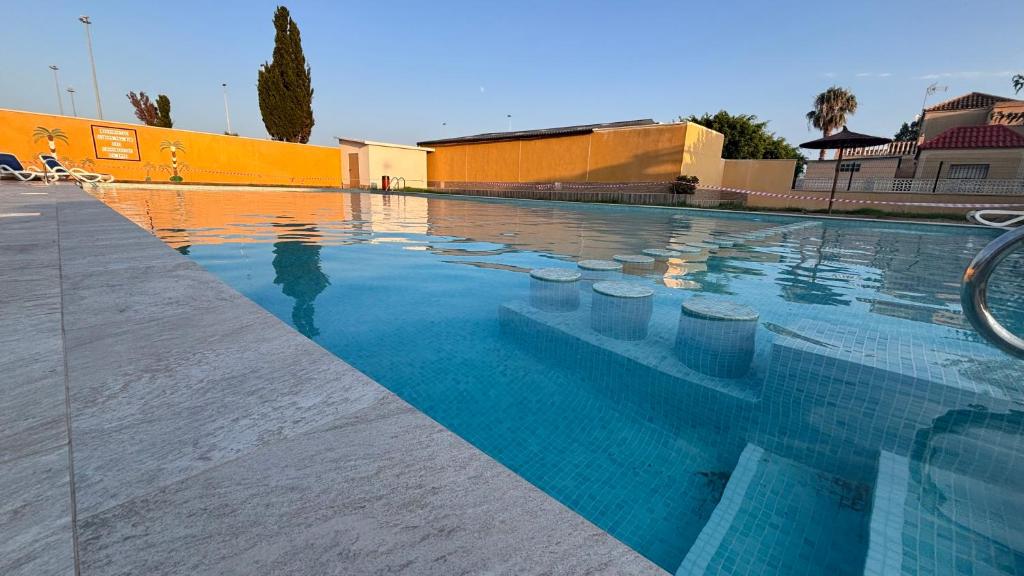 a swimming pool with blue water and rocks in it at CASA JARDIN DE MAR in Torrevieja