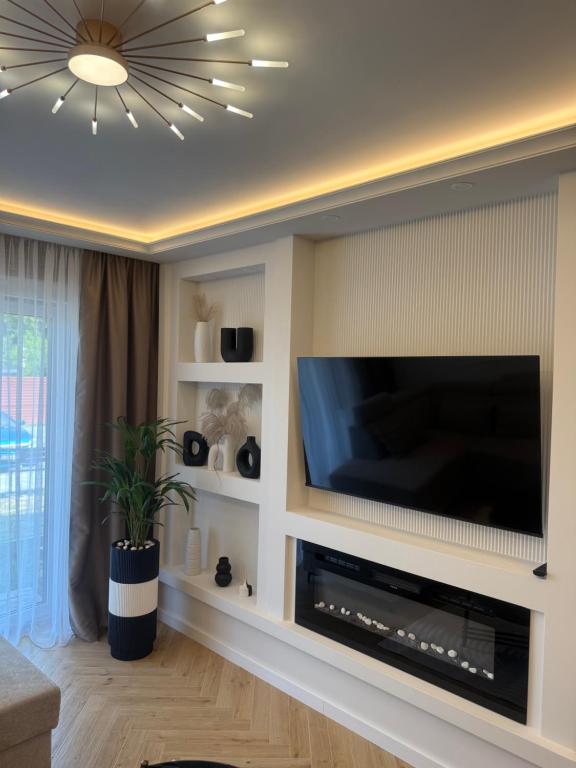 a living room with a flat screen tv on a wall at Apartament Anna De Lux z dużym tarasem in Zamość