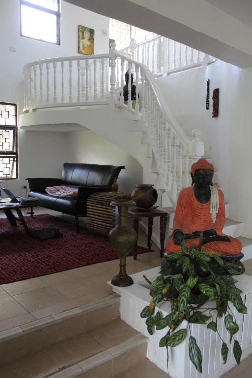 a living room with a staircase and a statue in a room at Residence71Nadi Fiji in Nadi