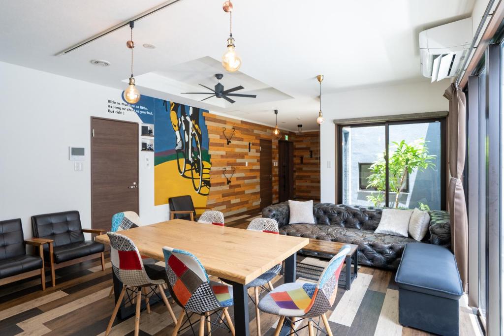 a living room with a wooden table and chairs at Cyclo Villa - JUNGLIA15分! 美ら海25分! ビーチ古宇利島すぐ! BBQ無料貸出! in Nago