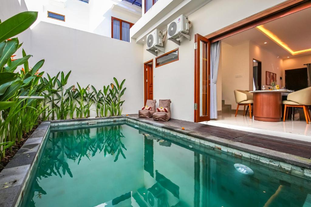 an indoor swimming pool in a house with a patio at Ellavie Villa Nusa Dua in Nusa Dua
