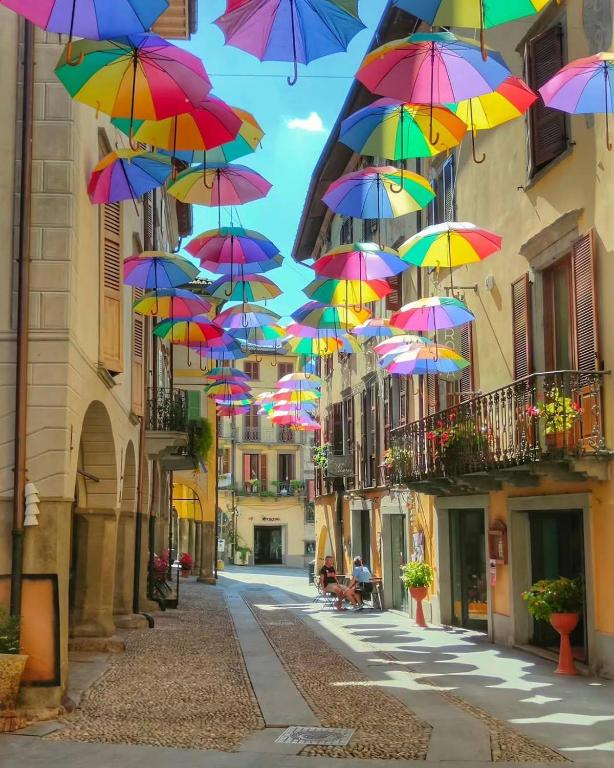a bunch of colorful umbrellas hanging over a street at Fanzago Home in Pisogne