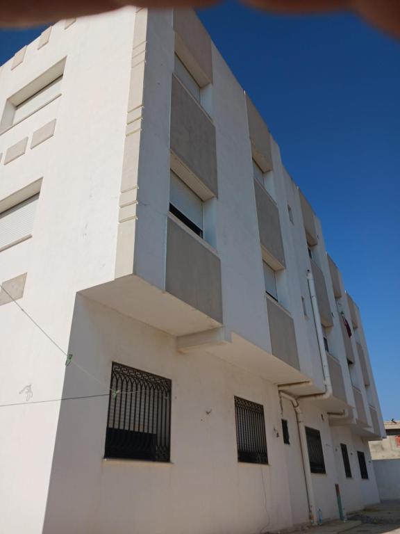a white building with black barred windows at soussoleil in Bin Rhilouf