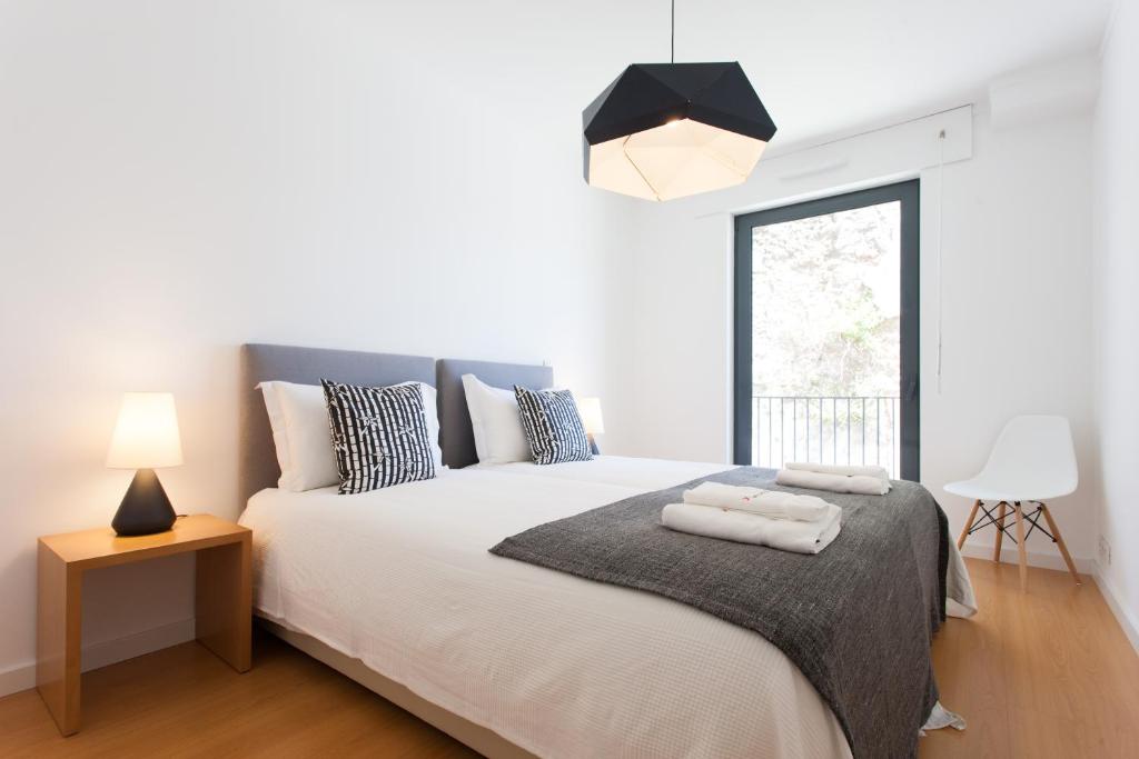 a bedroom with a bed with two towels on it at FLH Martim Moniz Modern Flat in Lisbon