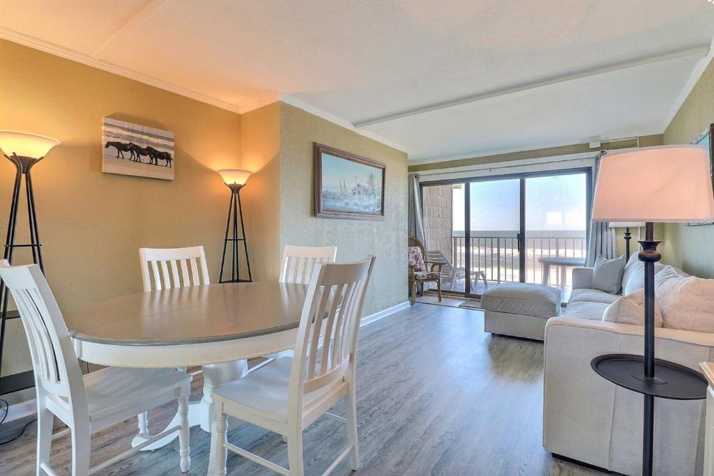 Una sala de estar con una mesa y sillas y un sofá. en DL301 - Dune Lantern 301, en Nags Head