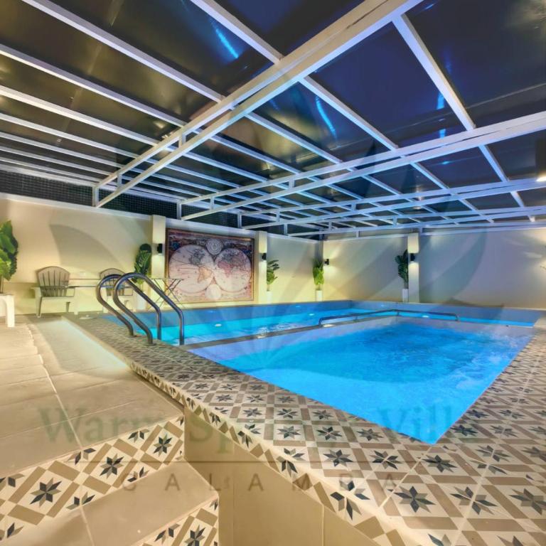 una gran piscina de agua azul en una habitación en Warm Springs Villa 1, en Calambá