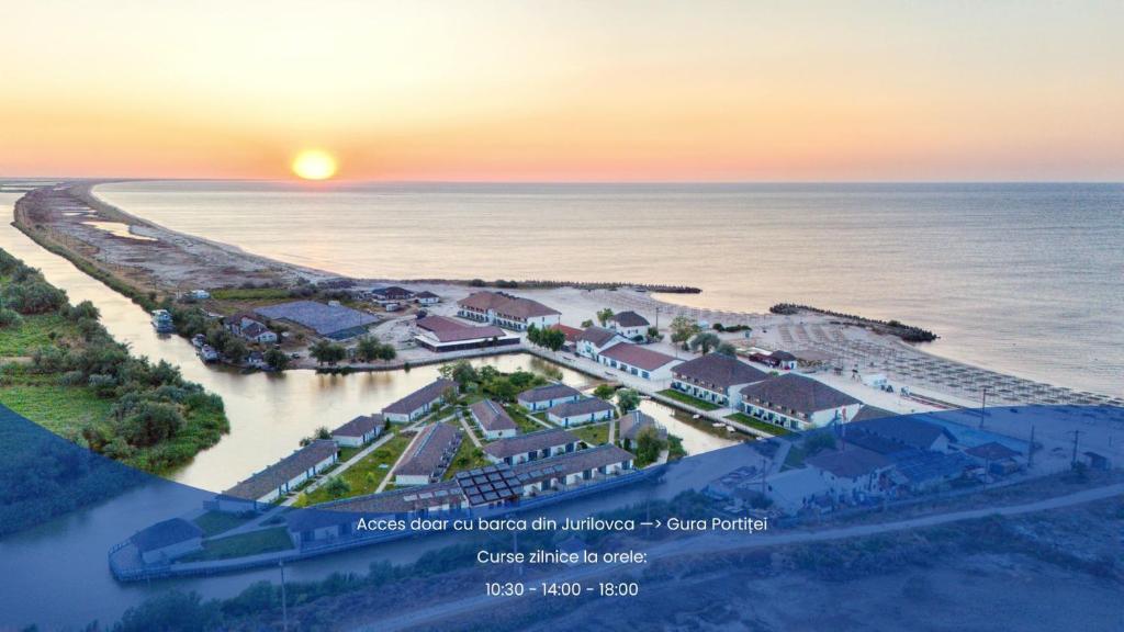 eine Luftansicht eines Resorts am Strand bei Sonnenuntergang in der Unterkunft Gura Portitei Resort in Jurilovca