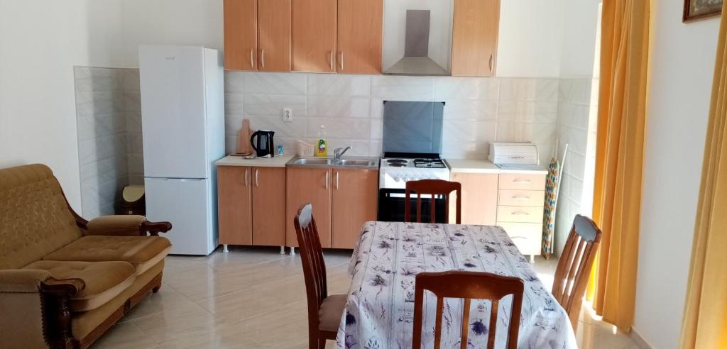 cocina con mesa, sofá, mesa y sillas en Apartmani Maric, en Tivat