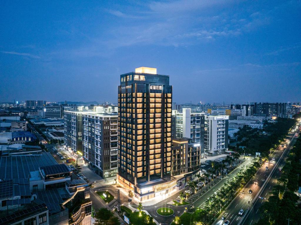 ShundeBodun International Apartment Foshan Shunde Fengjian Water Village Branch的夜晚城市中的高楼