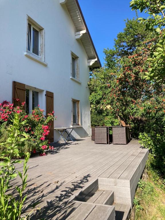 a wooden deck in front of a white house at Le Gîte d'Orion in La Bresse
