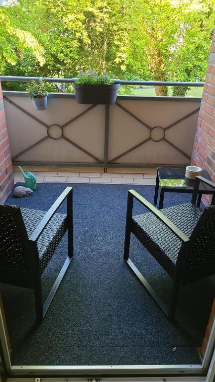 two chairs and a table on a balcony at Schönes 2-Zi. App. 55 qm - voll möbliert - citynah in Elmshorn