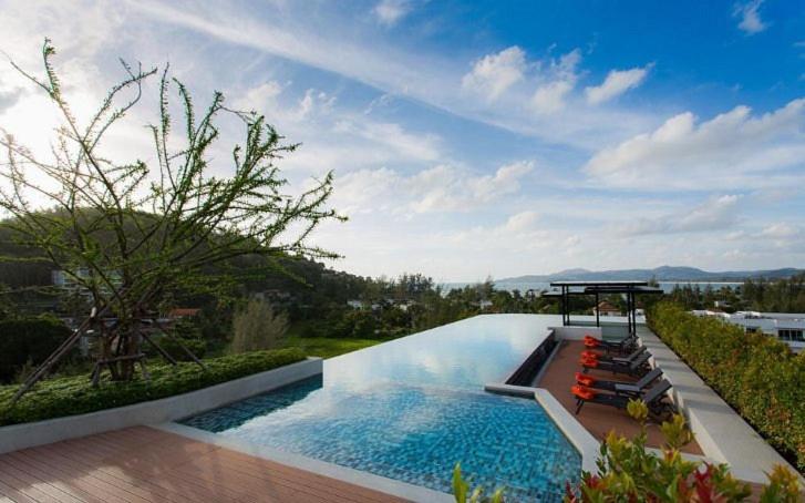 a swimming pool with lounge chairs next to at Superb Apartment! 5 Mins to the Beach in Ban Lum Fuang
