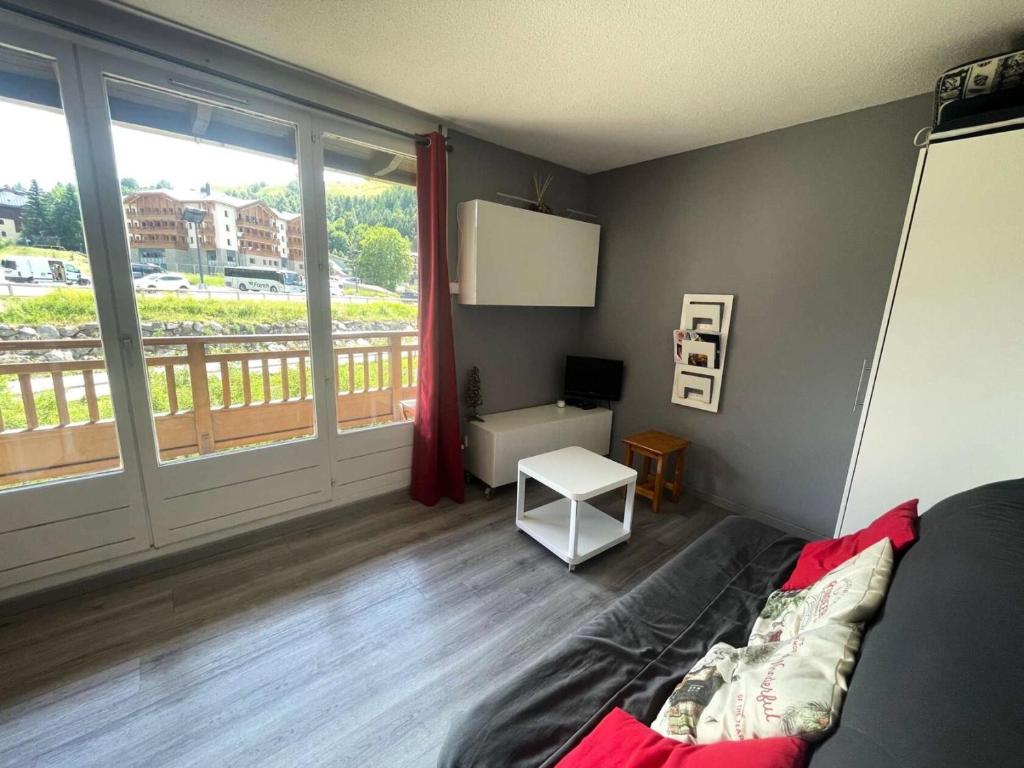 un salon avec un canapé et une grande fenêtre dans l'établissement Résidence Alpina 3 - Agréable appartement T3 secteur calme pied des pistes MAE-5481, à Vénosc