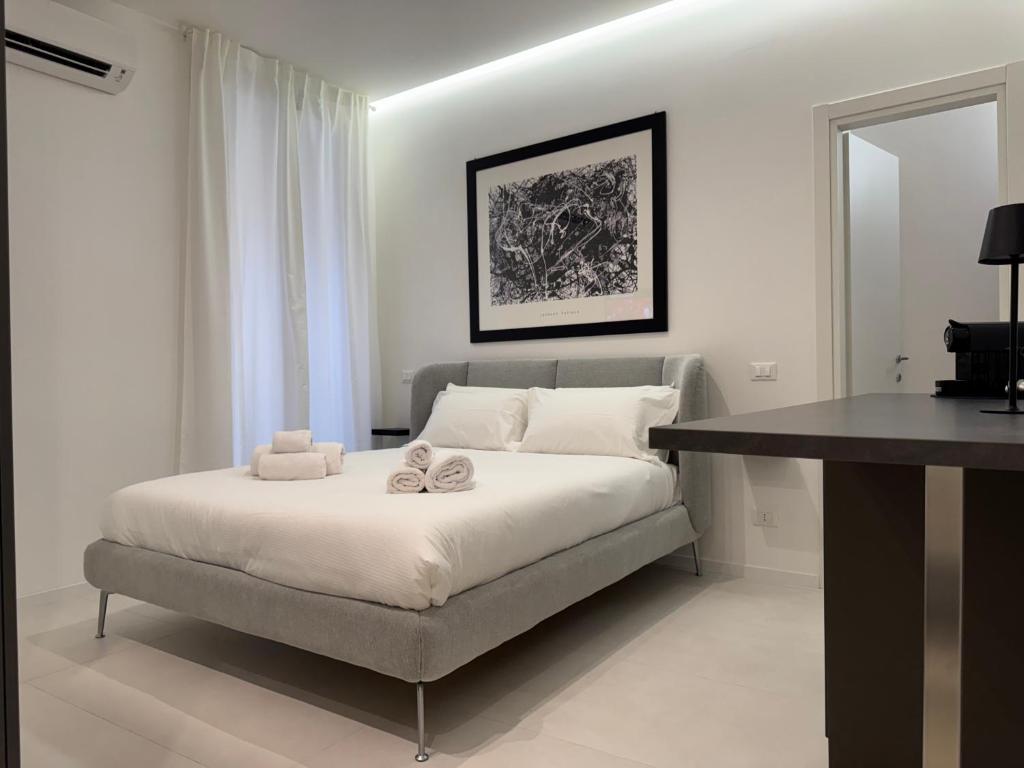 a bedroom with a bed with two towels on it at Mama suites Politeama in Palermo