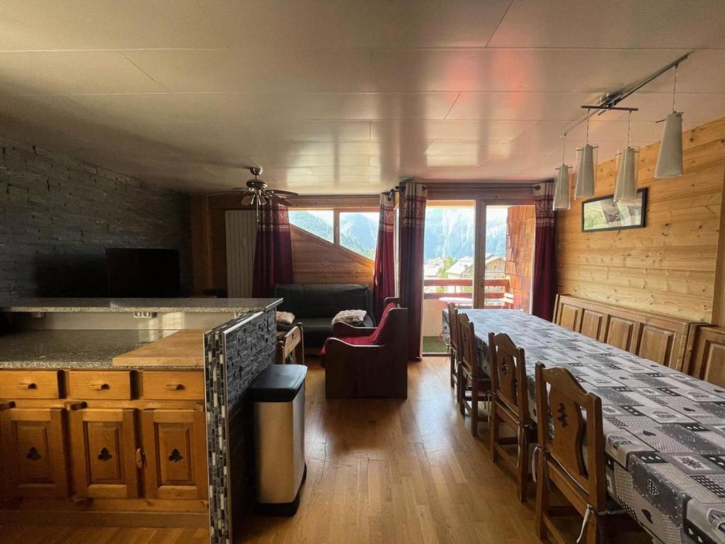 une cuisine avec une table et des chaises dans une pièce dans l'établissement Résidence Les Bleuets - Appartement Coup de coeur en Plein Centre de station avec cave privative MAE-5391, à Vénosc