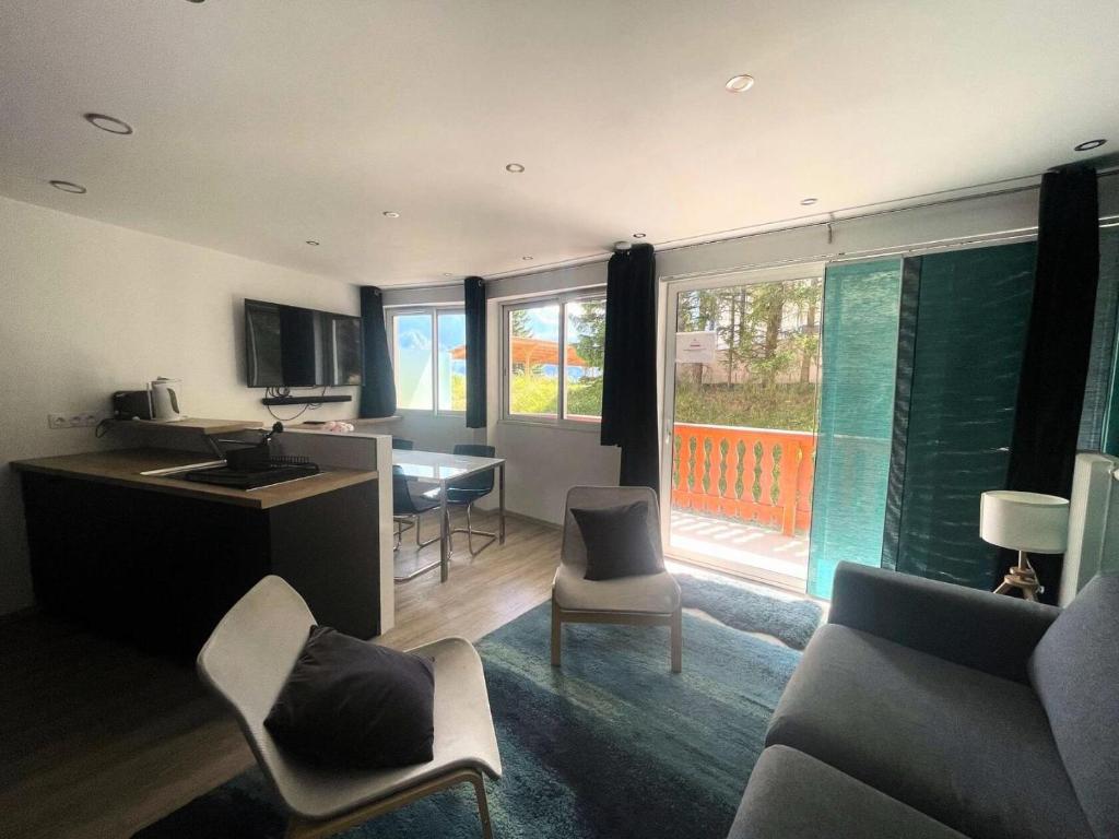a living room with a kitchen and a table and chairs at Résidence Midi - Les Deux Alpes – Appartement tout confort avec balcon plein sud et vue sur la Muzelle MAE-5511 in Les Deux Alpes