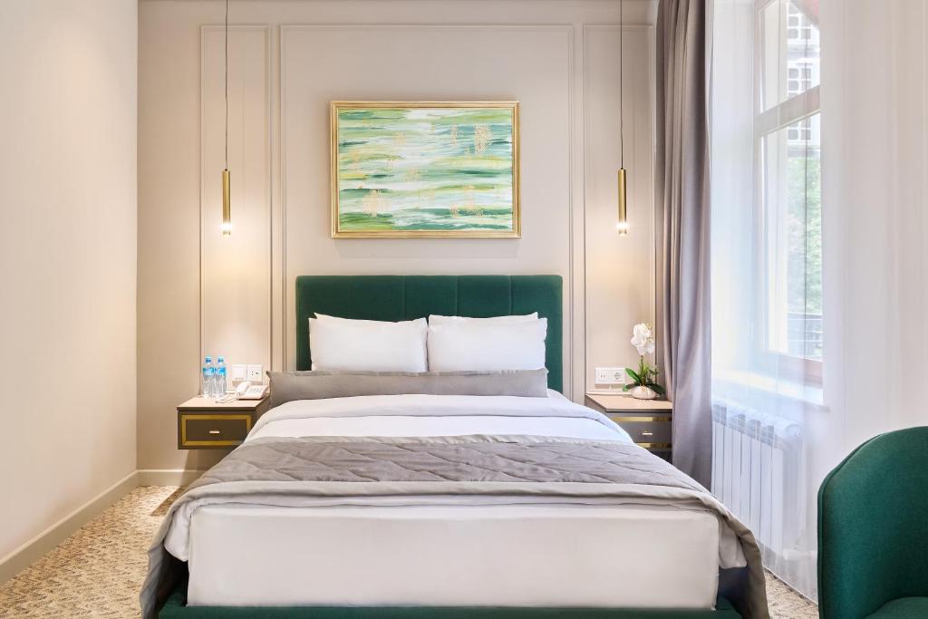 Un dormitorio con una cama grande con cabecero verde. en Maestro Address Baku Hotel, en Baku