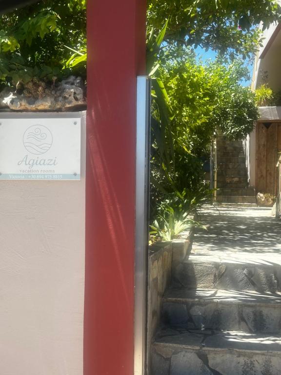 a sign on the side of a building next to some stairs at Agiazi Vacation Rooms Pitsidia in Pitsidia
