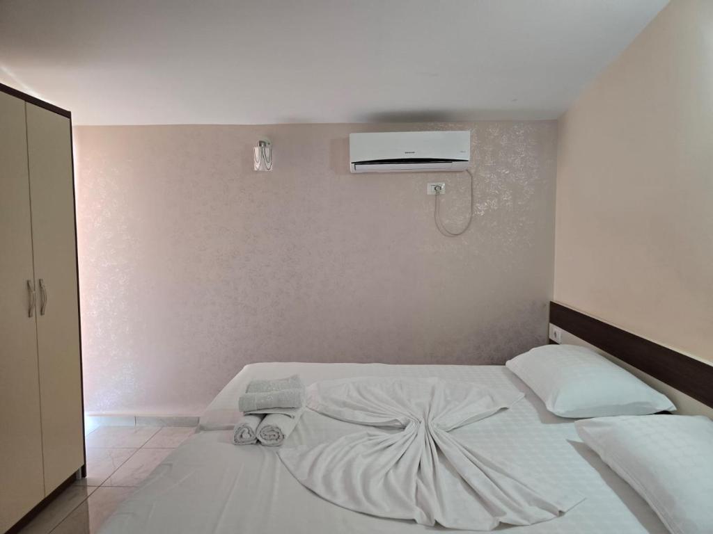a bedroom with a white bed with a fan at TRiAD in Vlorë
