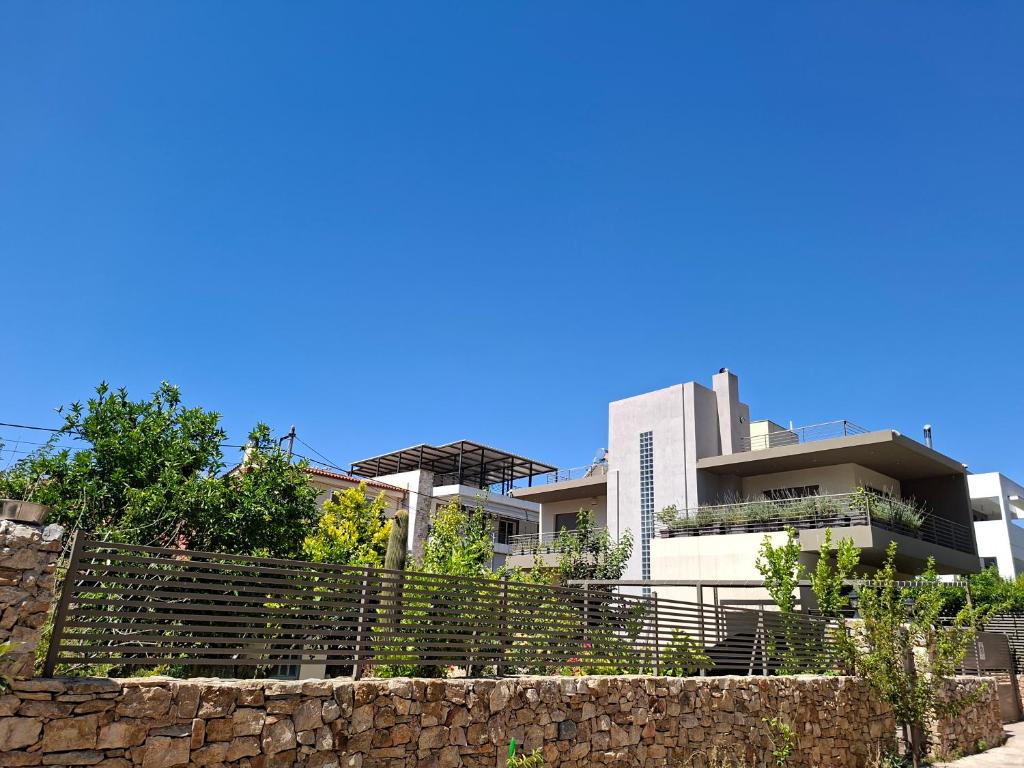 a building with a stone wall in front of a building at Maisonette in Marousi in Athens