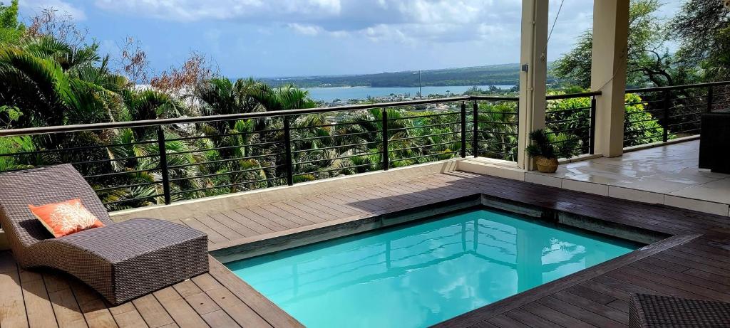 a small swimming pool on a balcony with a chair at Seaview Villa,Black River Private Pool and Sunset in Tamarin