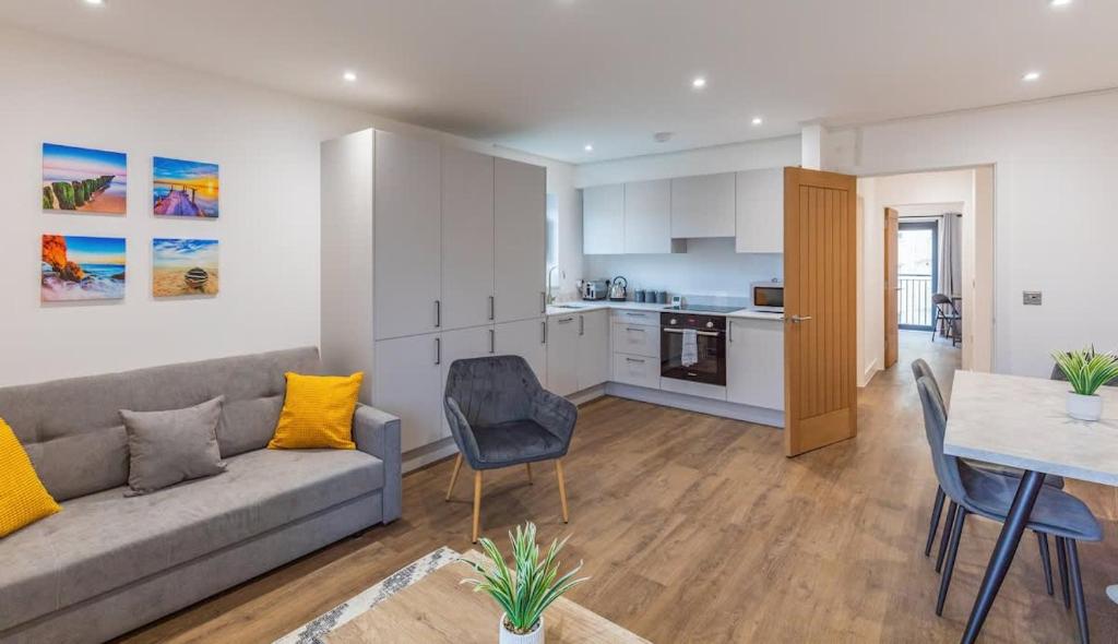 Hotel Central 2 Bed 2 Bath Apartment near Brighton College, Beach, Hospital - Long Stay Offers, a living room with a couch and a table and a kitchen at Central 2 Bed 2 Bath Apartment near Brighton College, Beach, Hospital - Long Stay Offers in Brighton & Hove
