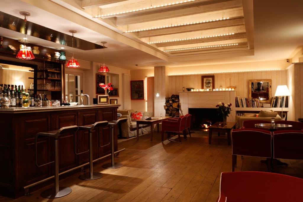 a restaurant with a bar and some tables and chairs at Le Lodge Kerisper in La Trinité-sur-Mer