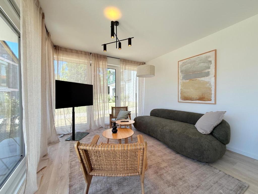 a living room with a couch and a tv at Suite Happiness in Uhldingen-Mühlhofen