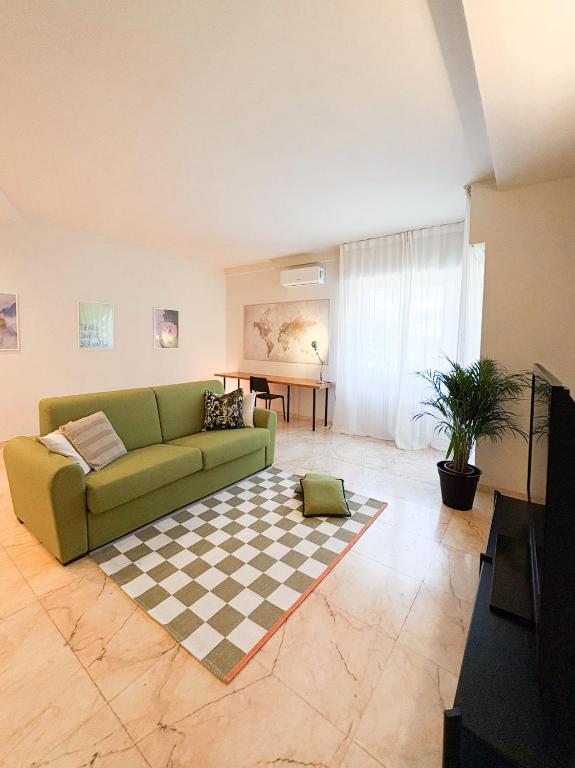 a living room with a green couch and a checkered rug at Borgo Design Apartment by the sea in Civitavecchia