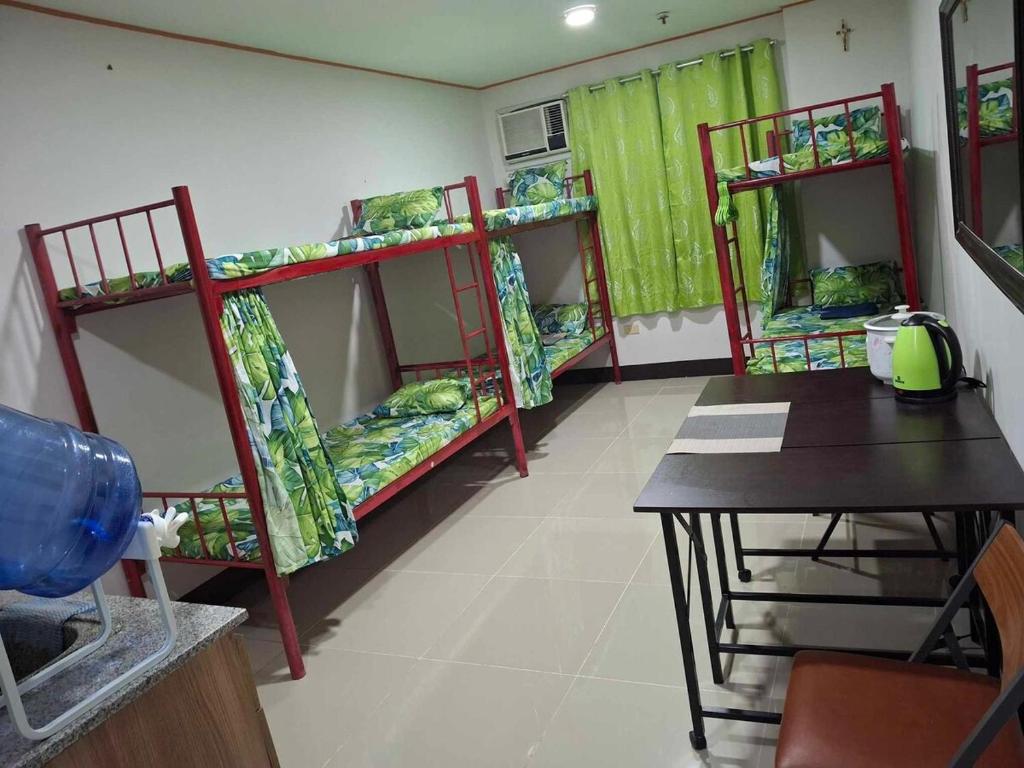 a room with three bunk beds and a table at Room for rent - SMR in Cebu City