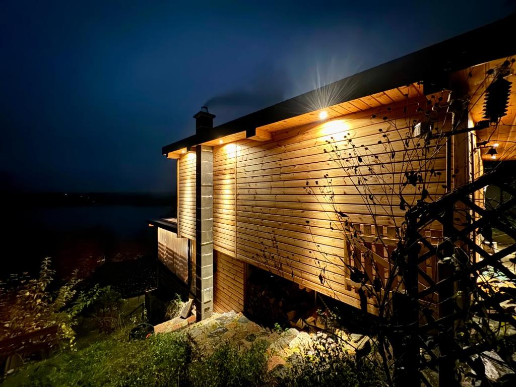 a building with a light on the side at night at LakeView DomekNaKaszubach in Parchowo