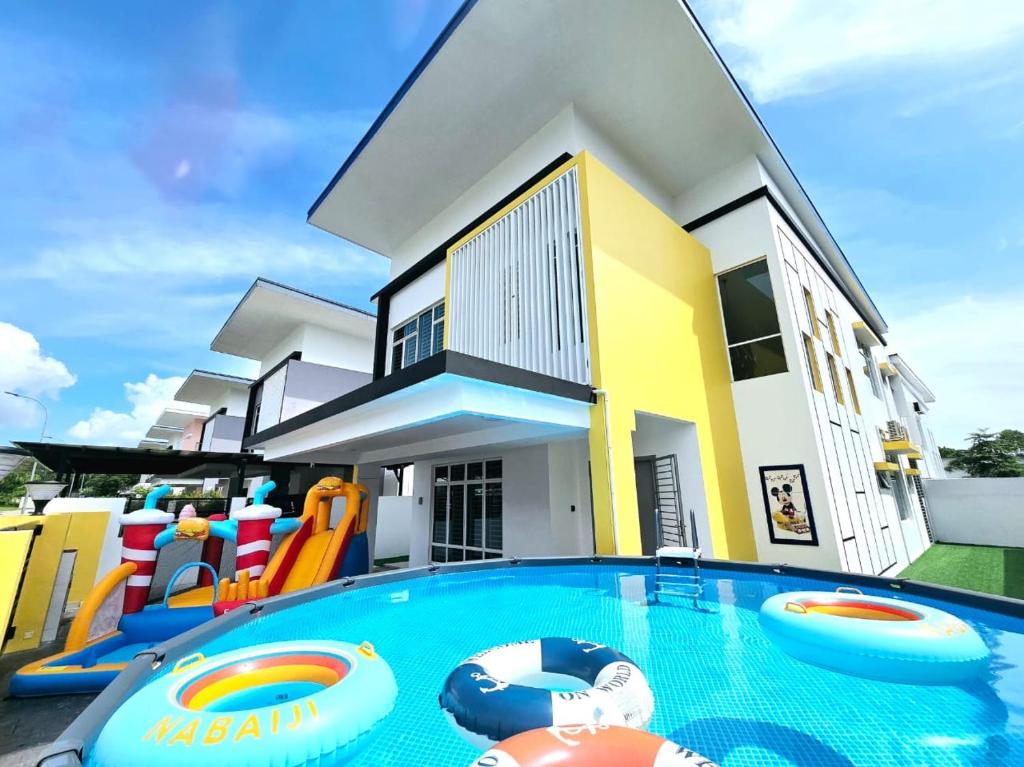 a house with a swimming pool in front of a house at TropINN LoDonHeartBeat 5LuxRoom CirPool BBQ & KTVFun in Bandar Penawar