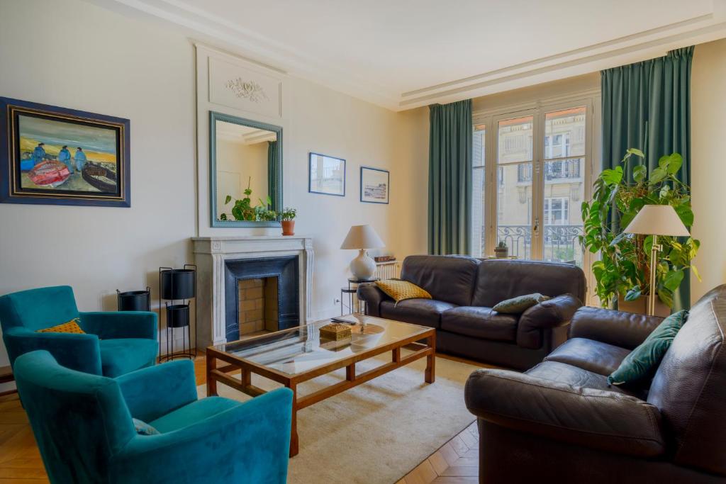 un salon avec des canapés et une cheminée dans l'établissement Paris Palais des Congrès Residence, à Neuilly-sur-Seine