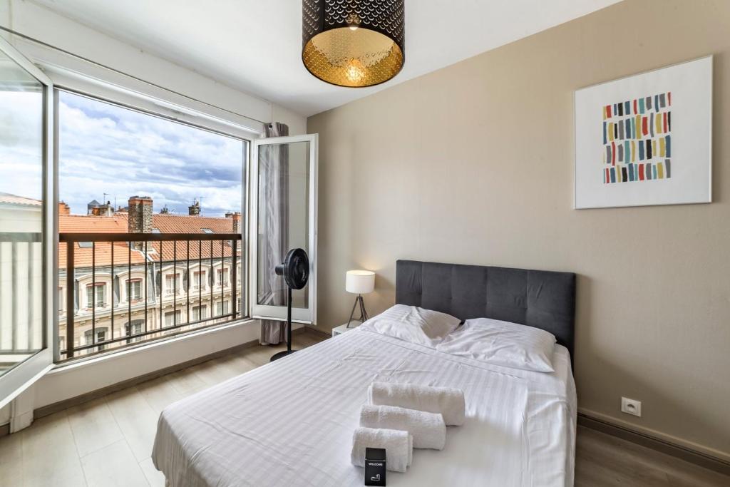 une chambre avec un lit et une grande fenêtre dans l'établissement Studio Hypercentre avec vue sur le vieux Lyon AIL, à Lyon