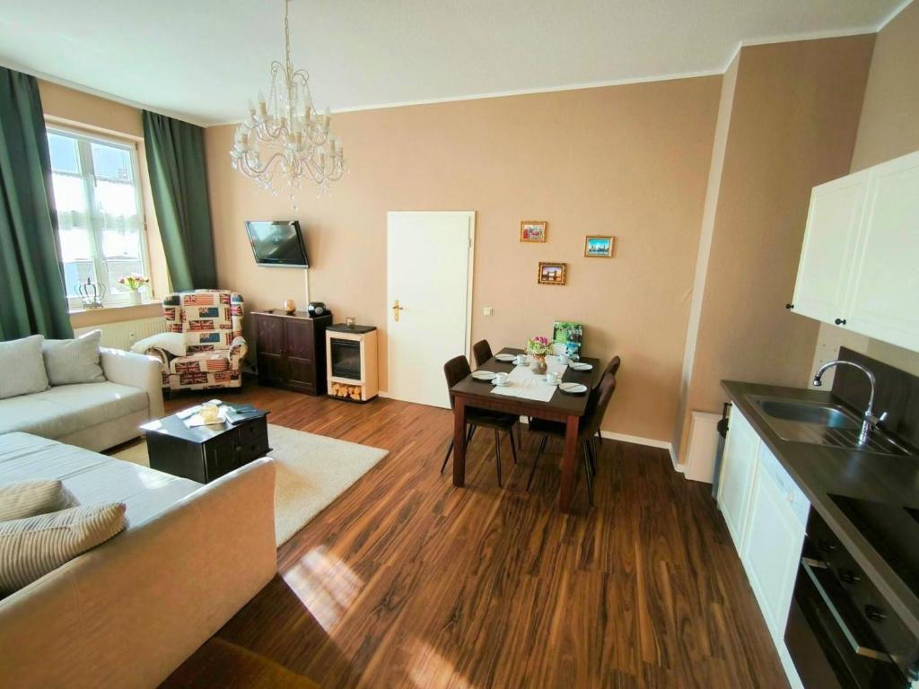 a kitchen and living room with a table and a couch at Apartment London Garten & Pool als Extra möglich barrierefrei in Mühlhausen