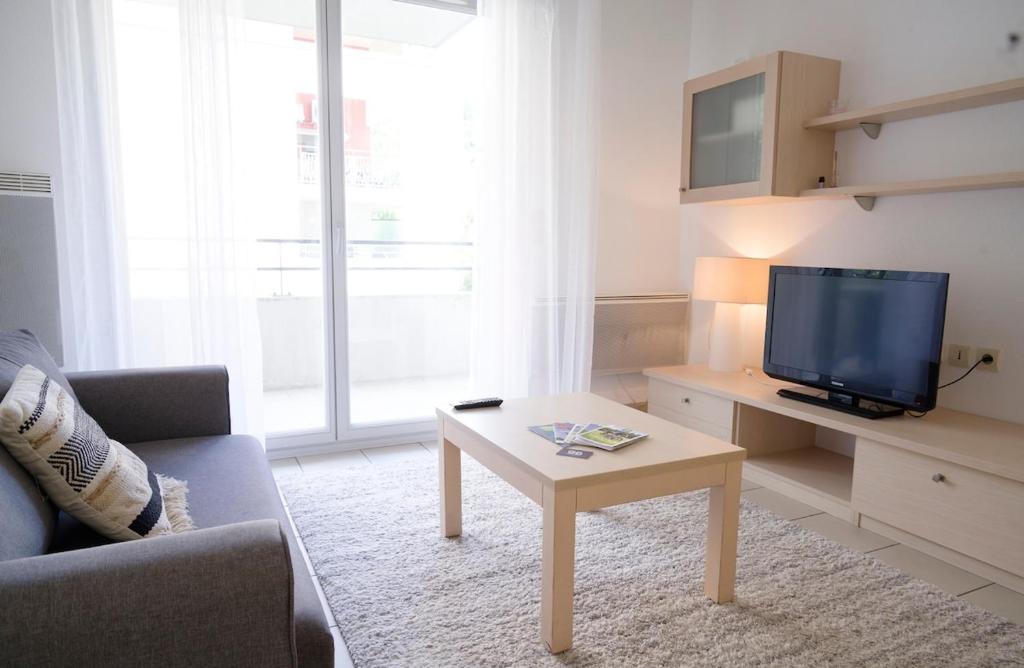 a living room with a tv and a coffee table at Studio climatisé à Divonne-les-Bains in Divonne-les-Bains