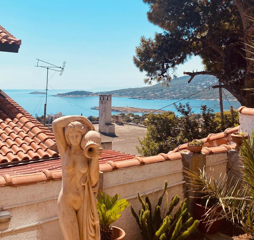 a statue of a woman standing on a wall at Ifigenia sea view in Artemida