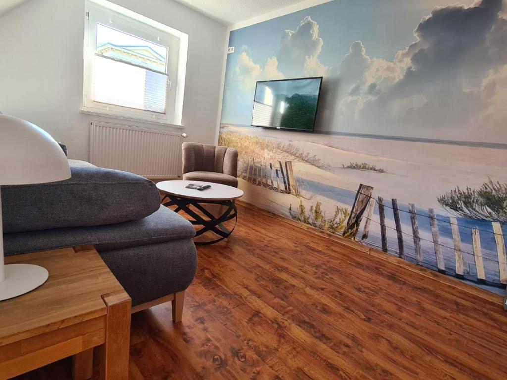 Una sala de estar con un sofá y un televisor en una pared. en Ferienwohnung Seemöwe Usedom, en Heringsdorf