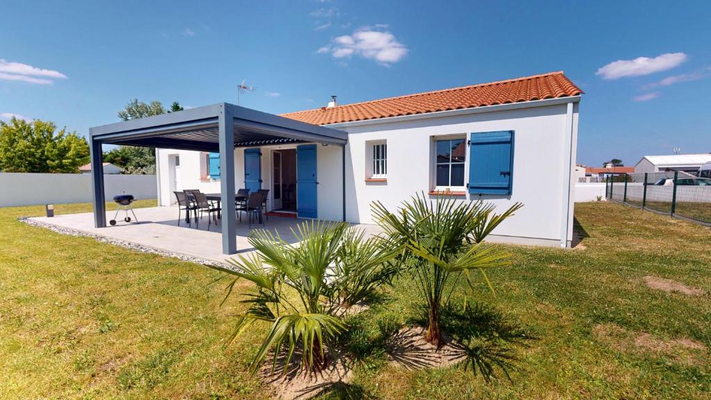una pequeña casa blanca con techo azul en Oceana de l Isle de Riez, en Saint-Hilaire-de-Riez