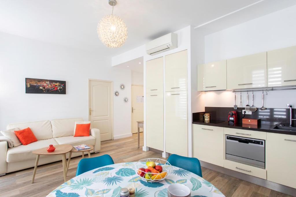 une cuisine et un salon avec une table et un canapé dans l'établissement #28 1 BDR Flat AC Balcony Hper Central 10mins to Beach & old town, à Nice