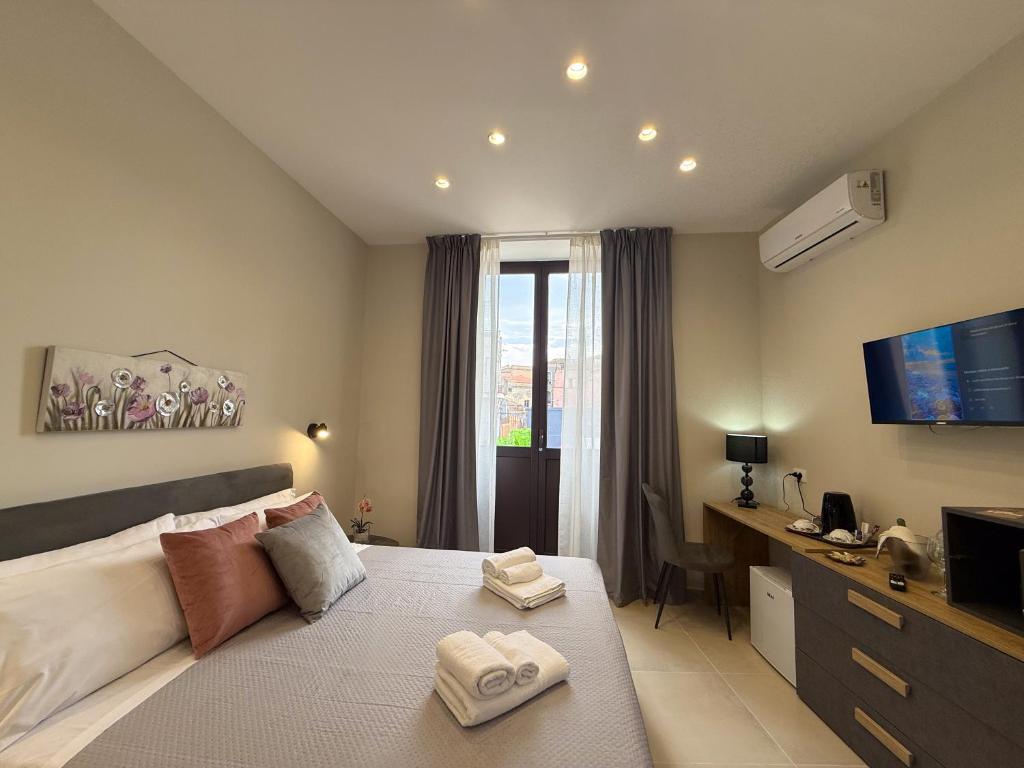 カターニアにあるTown House 54のベッドとタオル2枚のある寝室