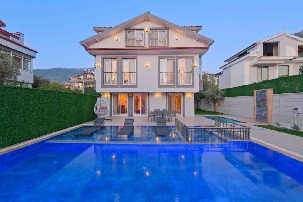 una casa con piscina delante de una casa en Yaz Villa 2, en Fethiye