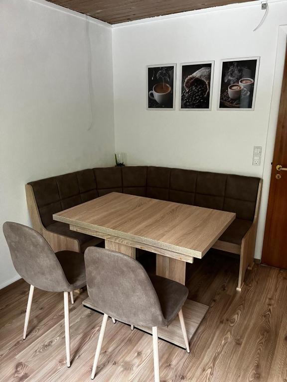 ein Holztisch mit zwei Stühlen und ein Tisch und ein Sofa in der Unterkunft Holiday Nest 2 in Sønderborg