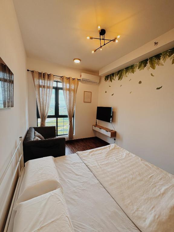a bedroom with a large white bed and a couch at K-Avenue by FFix-Stay in Donggongon