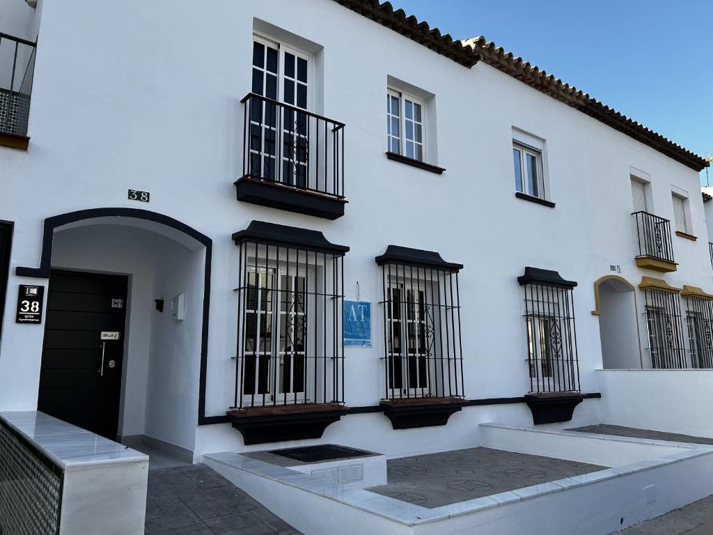 a white building with barred windows and a door at LEON 38 Apartments Private Parking - EaW Homes in Estepona