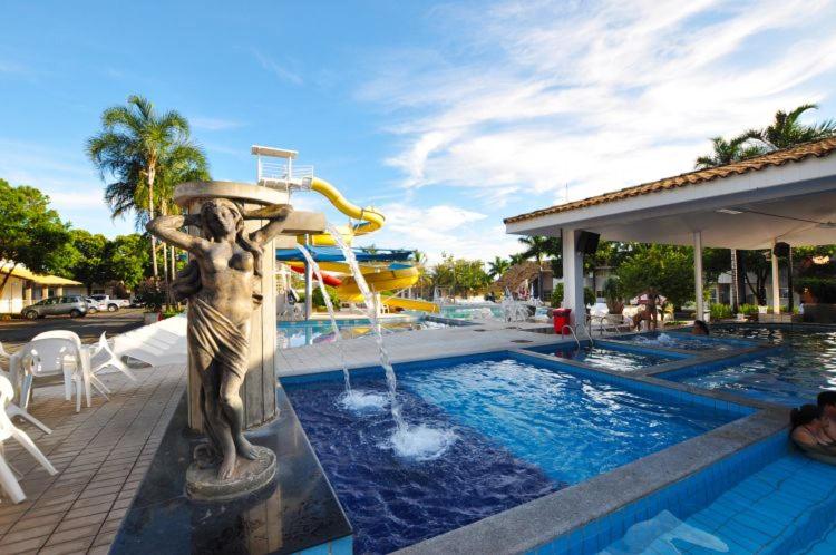 una estatua junto a una piscina con tobogán de agua en Via Caldas Internacional Resorts, en Caldas Novas