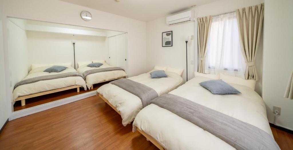 a bedroom with three beds and a mirror at Casa G,S, - Vacation STAY 53492v in Osaka