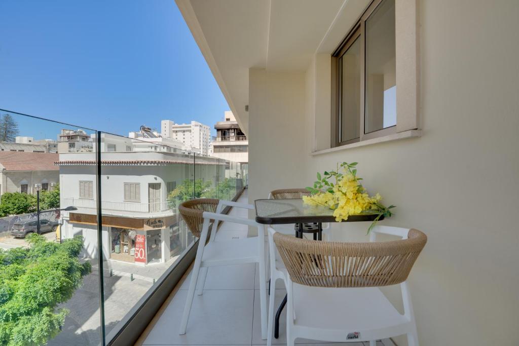 a balcony with a table and chairs and a view at Lemon Paradise City centre 200m from beach in Larnaca
