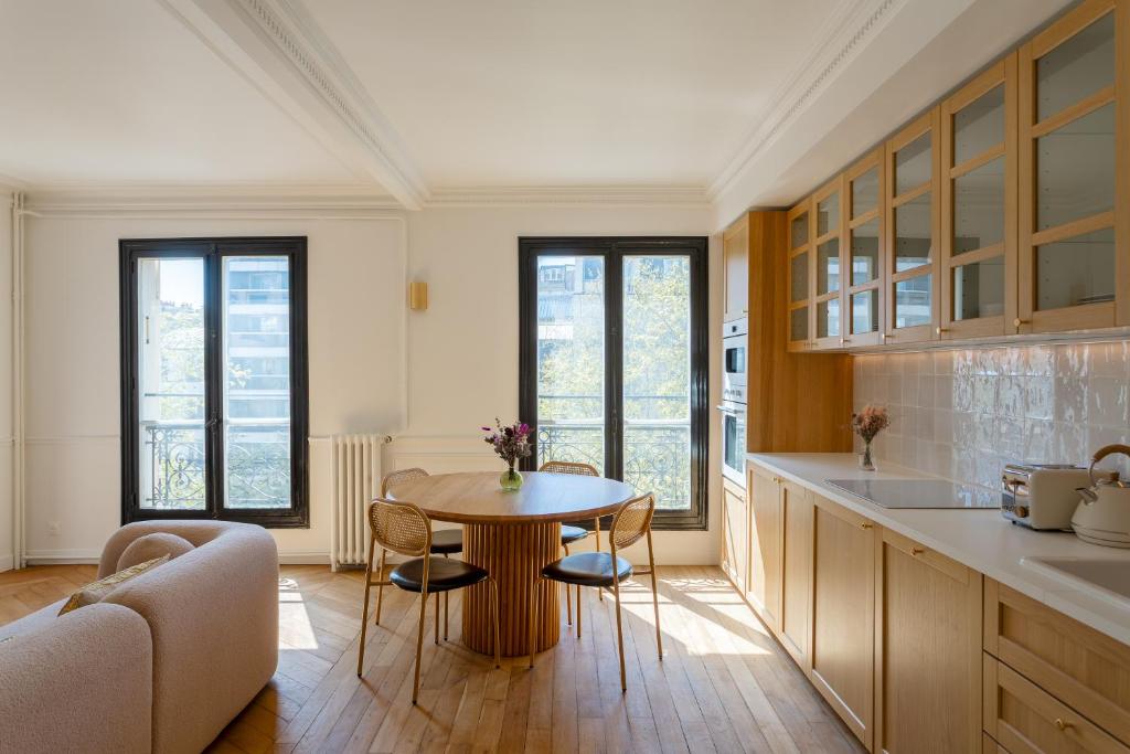 une cuisine avec une table et des chaises dans une pièce dans l'établissement Rive Gauche Light and Elegance, à Paris